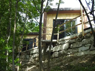 a house built on a stone wall at Počitniški hišici - Small holiday houses in Ajdovščina