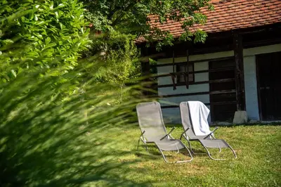 two chairs sitting in the grass in front of a house at Martin's Family Cottage with Hot Tub & Views in Šmarje pri Jelšah