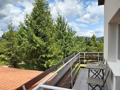 a balcony with a table and chairs and a tree at Divača, Vila Srebrna in Divača