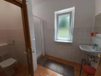 a bathroom with a toilet and a sink and a window at Divača, Vila Srebrna in Divača