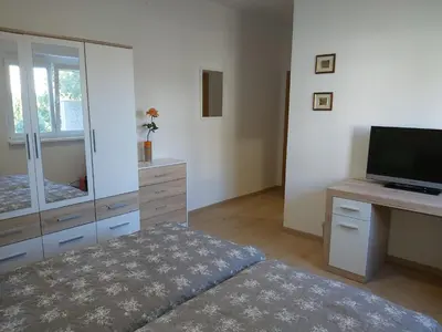 a bedroom with a television and a dresser with a mirror at Divača, Vila Srebrna in Divača