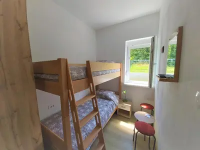 a small room with bunk beds and a window at Divača, Vila Srebrna in Divača