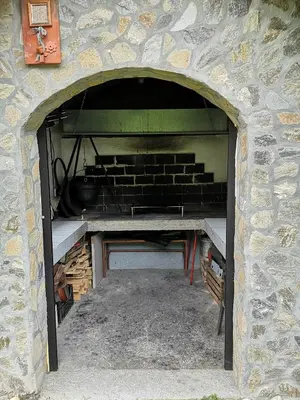 a brick oven with a table inside of it at Apartma Juteršek in Libeliče