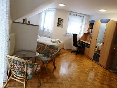 a bedroom with a bed and a table and chairs at Apartma Juteršek in Libeliče