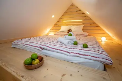 a bed with a teddy bear and apples on it at Bohinj - Apartment Ana in Bohinj