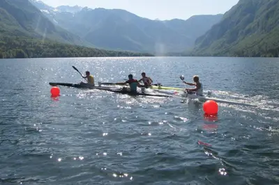 a group of people rowing a boat on a lake at Bohinj - Apartment Ana in Bohinj