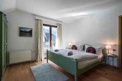 a bedroom with a green bed and a window at Hiša MIHA Stunning Spacious House & Apartment Podkoren Kranjska Gora in Kranjska Gora