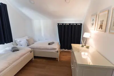 a bedroom with two beds and a desk and a window at Hiša MIHA Stunning Spacious House & Apartment Podkoren Kranjska Gora in Kranjska Gora