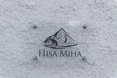 a sign on the side of a building with a mountain at Hiša MIHA Stunning Spacious House & Apartment Podkoren Kranjska Gora in Kranjska Gora