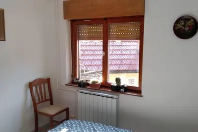 a bedroom with a chair and a window with a radiator at ZRM center in Idrija