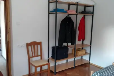 a room with a shelf with a chair and a suitcase at ZRM center in Idrija