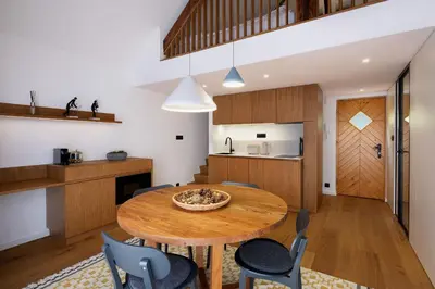 a kitchen and dining room with a wooden table and chairs at Private beach house on Lake Bled in Bled