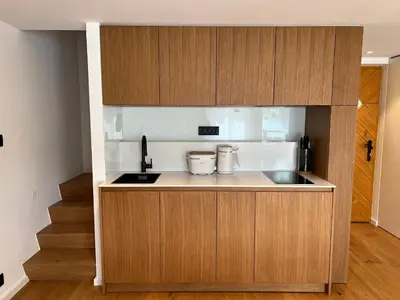 a kitchen with wooden cabinets and a sink at Private beach house on Lake Bled in Bled