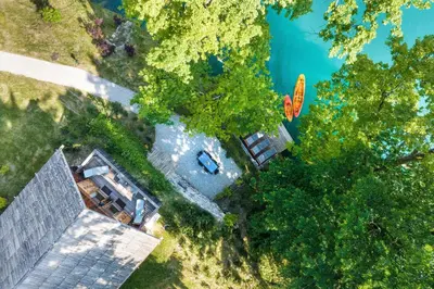 an overhead view of a house with trees and a lake at Private beach house on Lake Bled in Bled