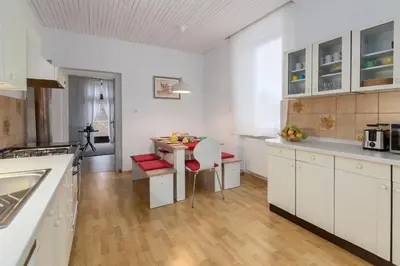 a kitchen with white cabinets and a small table with a tablektop at OPN Apartments Bled in Bled