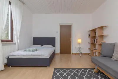 a bedroom with a bed and a couch at OPN Apartments Bled in Bled