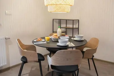 a black table with chairs and a plate of food on it at OPN Apartments Bled in Bled