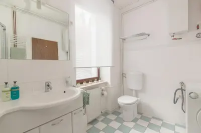 a white bathroom with a sink and a toilet at OPN Apartments Bled in Bled