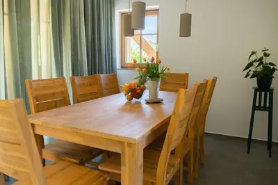 a wooden table with chairs and a vase of fruit on it at SKED'N in Bled