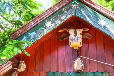 a small red building with a roof with a utensil at House Moose't Getaway, Kranjska Gora in Kranjska Gora