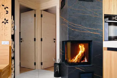 a fireplace in a living room with a stove at Luxury Alpine Chalet & Sauna Pinja - Velika Planina - I FEEL ALPS in Stahovica