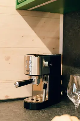 a coffee maker sitting on a counter next to a wine glass at Chalet Lepenatka with Sauna - I feel Alps in Stahovica