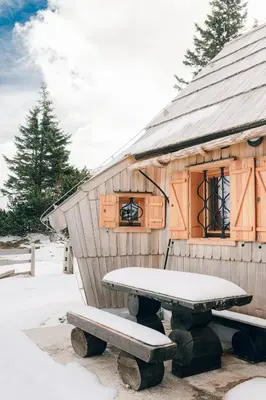 a picnic table in front of a small house at Chalet Lepenatka with Sauna - I feel Alps in Stahovica