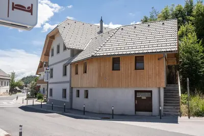 a house with a wooden roof on a street at Apartments Janko in Bled