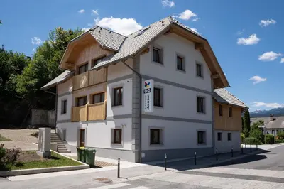a large white building with a wooden roof at Apartments Janko in Bled