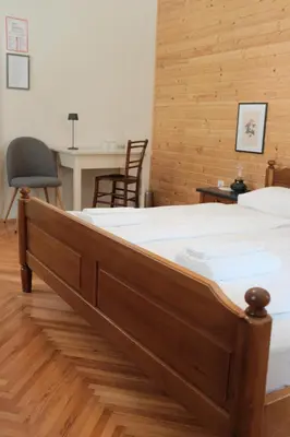 a bed in a room with a desk and a chair at Gorska Roža in Log pod Mangartom