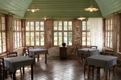 a dining room with tables and chairs and windows at Gorska Roža in Log pod Mangartom
