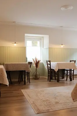 a dining room with tables and chairs and a window at Gorska Roža in Log pod Mangartom
