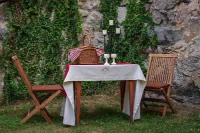 a table with a wicker basket and two chairs at Rooms & Apartments Podsreda Castle in Podsreda