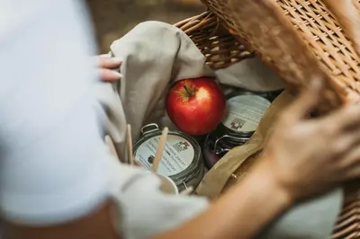 a woman holding a basket with an apple in it at Rooms & Apartments Podsreda Castle in Podsreda