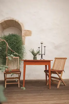 a wooden table and two chairs and a table with a candle at Rooms & Apartments Podsreda Castle in Podsreda