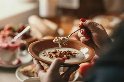 a person is eating a bowl of food at Rooms & Apartments Podsreda Castle in Podsreda