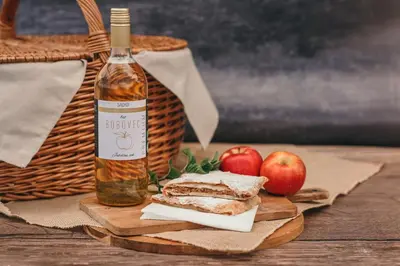 a bottle of wine and two apples on a table at Rooms & Apartments Podsreda Castle in Podsreda
