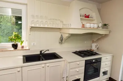 a white kitchen with a stove and a sink at Apartmaji Velikonja in Ajdovščina