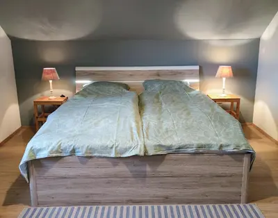 a bed in a bedroom with two lamps on two tables at vakantiehuis Zidanica in Žužemberk