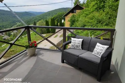 a balcony with a couch and a view of a mountain at vakantiehuis Zidanica in Žužemberk