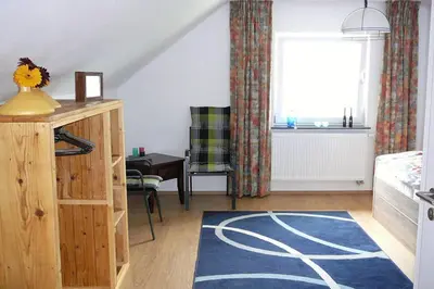 a living room with a large window and a blue rug at vakantiehuis Zidanica in Žužemberk