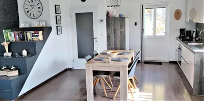 a kitchen with a table with chairs and a clock on the wall at vakantiehuis Zidanica in Žužemberk