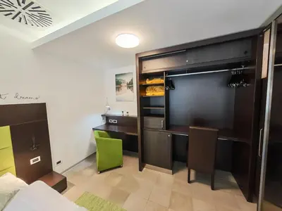 a bedroom with a bed and a desk with a green chair at Apartment Klara in Kranjska Gora