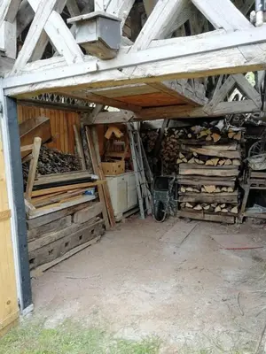 a barn with a pile of wood in a room at Country House Pri Lipet Žiri in Žiri