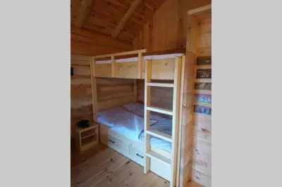 a bedroom with bunk beds in a log cabin at Hut at the forest in Male Brusnice