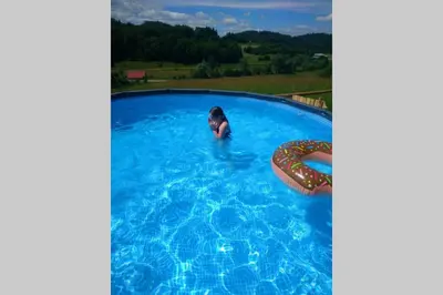 a person in a swimming pool with a raft at Hut at the forest in Male Brusnice