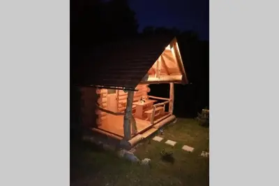 a dog house is lit up at night at Hut at the forest in Male Brusnice