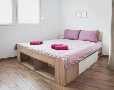 a bed with two pink pillows on top of it at Apartmaji Hrast - Podbela in Podbela