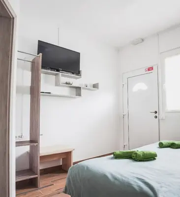 a bedroom with a bed and a flat screen tv at Apartmaji Hrast - Podbela in Podbela