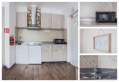 a kitchen with white cabinets and a sink and a microwave at Apartmaji Hrast - Podbela in Podbela